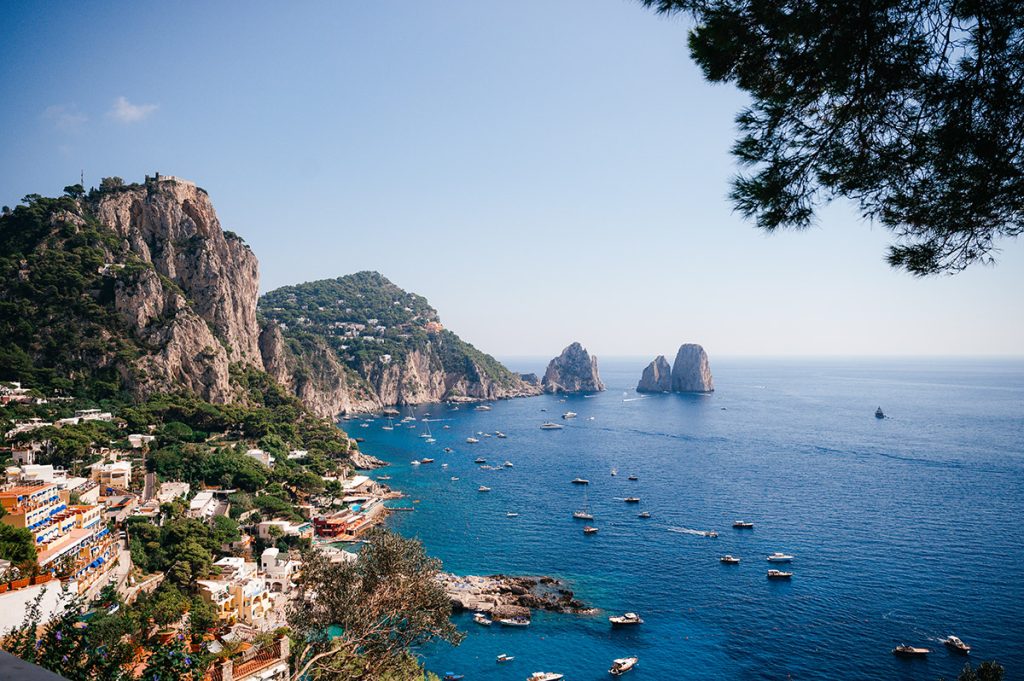 A breathtaking coastal view of Capri, captured by a Capri wedding photographer, featuring the Faraglioni and blue waters