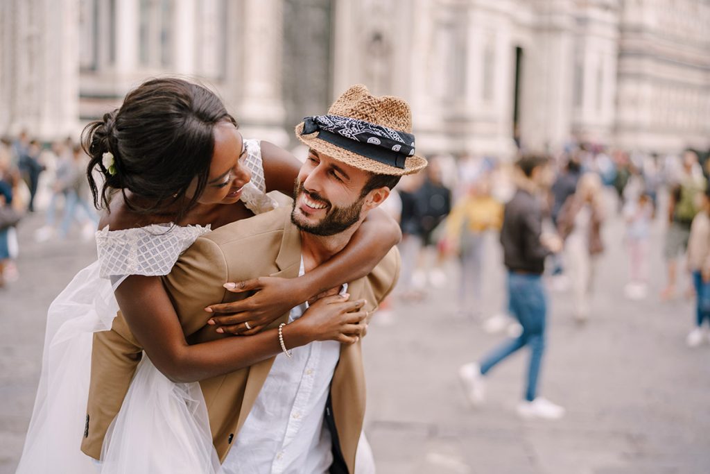 Bride piggybacking groom in Florence street, a candid moment by Florence wedding photographer
