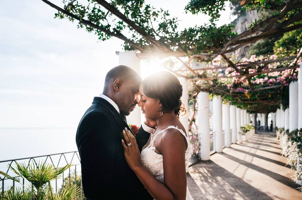 Wedding couple sharing an intimate moment under a pergola with columns on the Amalfi Coast