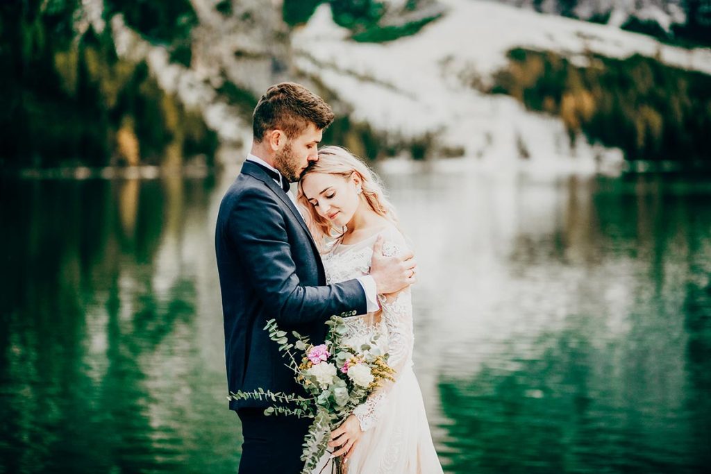 Italian Wedding Photographer highlights a tender moment between a couple by Lake Garda, capturing the lake's serene beauty