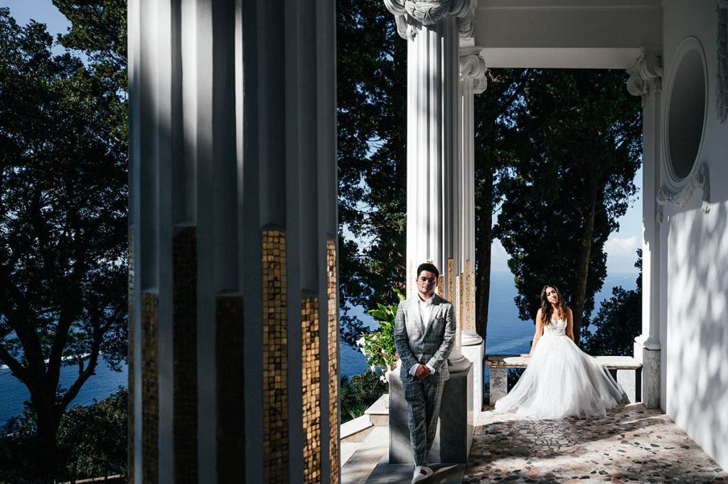 Bride and groom framed by architectural columns, capturing a romantic moment at a wedding in Capri location