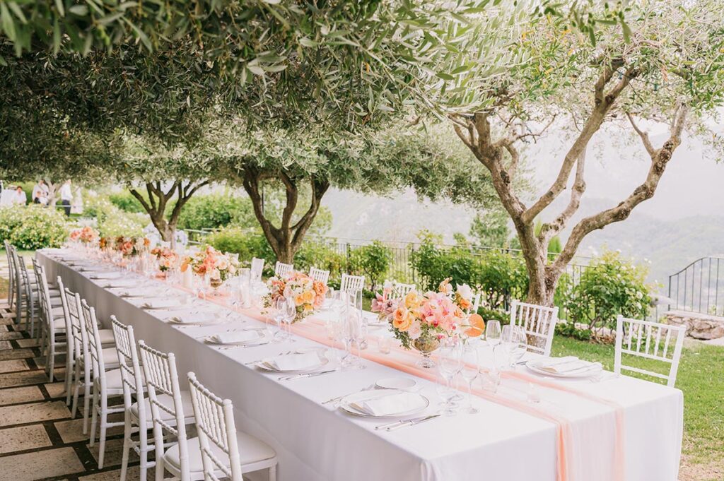 Long reception table decorated with flowers under olive trees at Belmond Hotel Caruso wedding Ravello