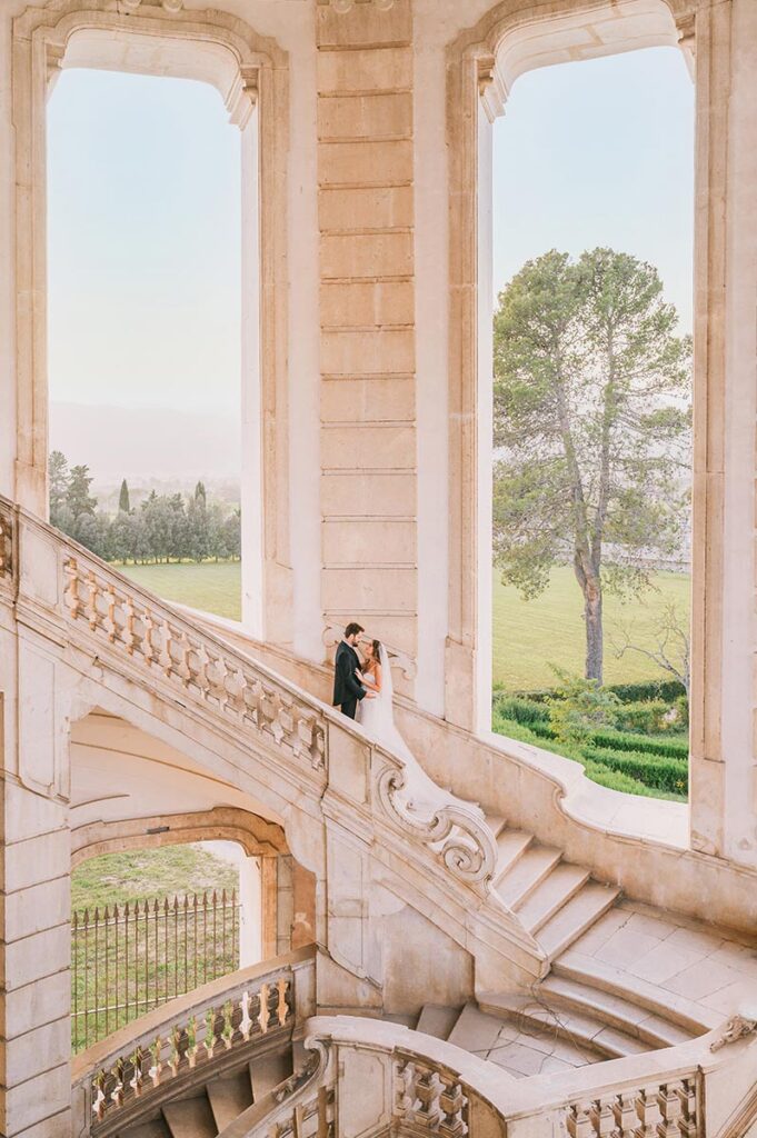 Bride and groom sharing a romantic moment on a grand staircase with Amalfi countryside views