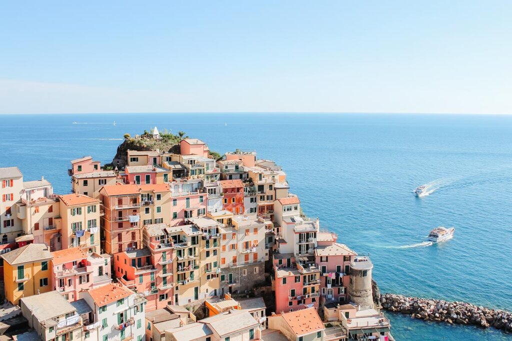 Italian Wedding Photographer captures a colorful Cinque Terre village by the sea, showcasing the unique coastal architecture