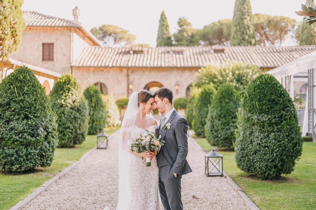 Elegant wedding in Perugia, Italy, with a bride and groom embracing amidst lush greenery and historic architecture