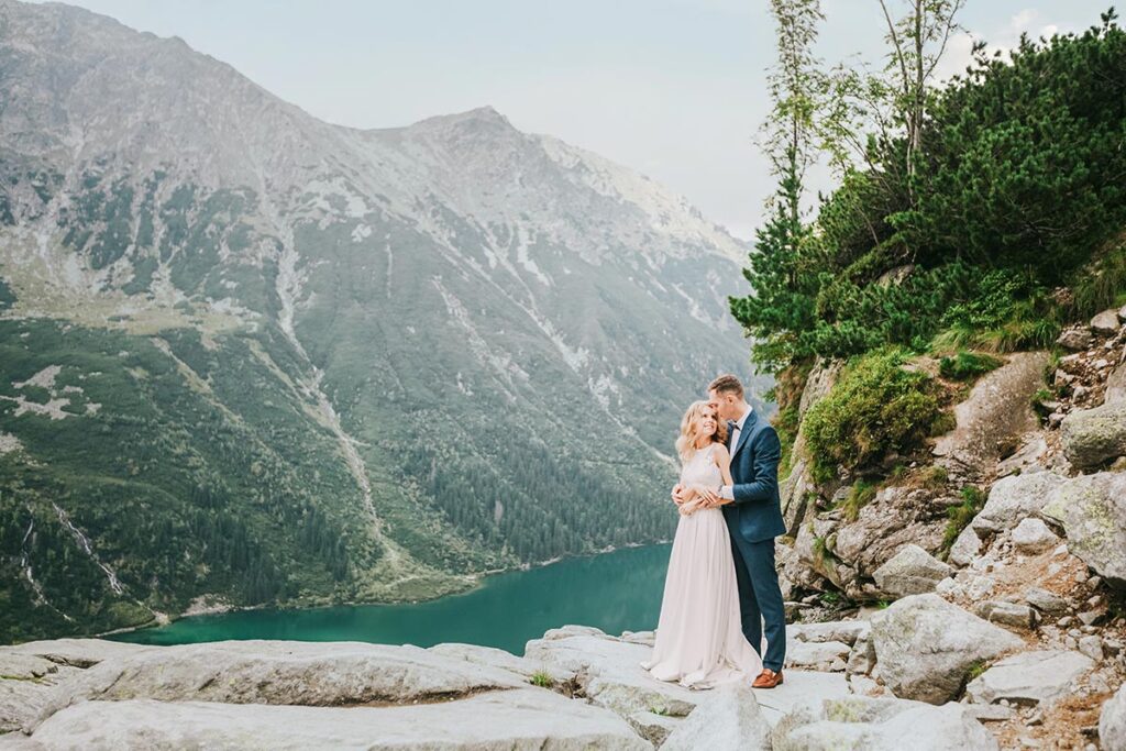 Couple embracing by the tranquil blue waters of an Italian lake during their romantic wedding
