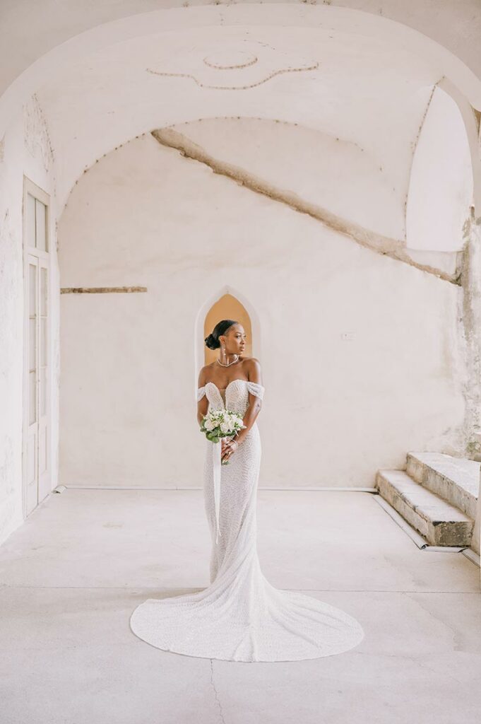 Bride in an elegant indoor setting holding a bouquet, captured by an Amalfi Coast wedding photographer